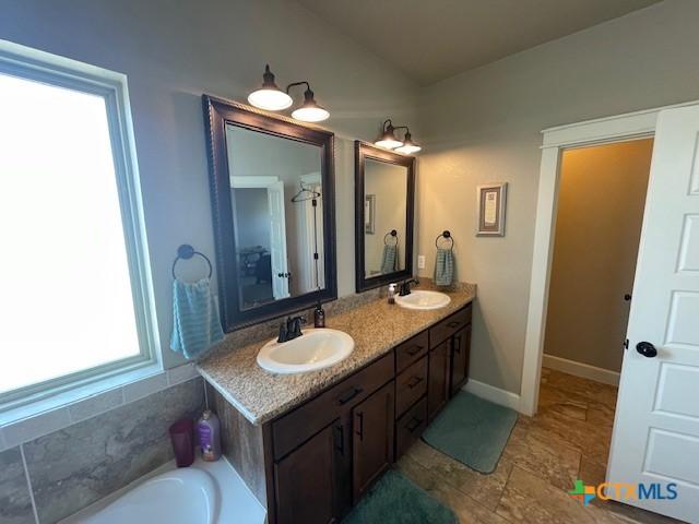 5618 County Road 3300, Kempner, TX 76539 - bathroom featuring double vanity, a garden tub, and baseboards