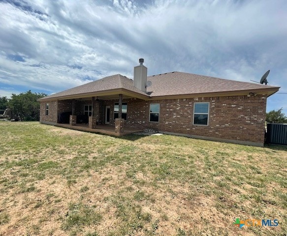 5618 County Road 3300, Kempner, TX 76539 - rear view of property featuring a lawn, brick siding, and a chimney