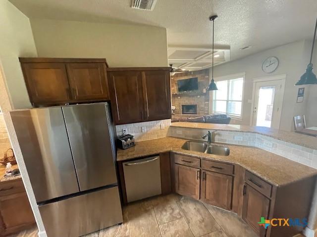 5618 County Road 3300, Kempner, TX 76539 - kitchen featuring appliances with stainless steel finishes, a sink, a ceiling fan, backsplash, and a textured ceiling