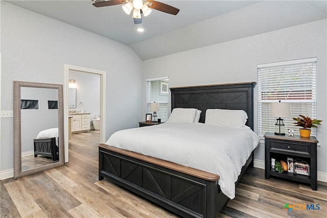 bedroom featuring hardwood / wood-style floors, ceiling fan, multiple windows, and vaulted ceiling