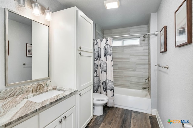 full bathroom with wood-type flooring, toilet, a textured ceiling, vanity, and shower / tub combo