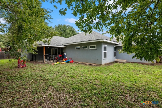 back of property featuring a lawn