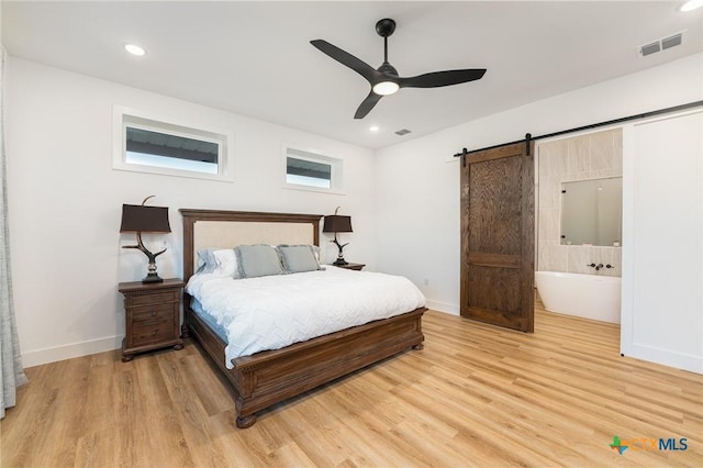 7817 W Fm 487, Florence, TX 76527 - bedroom featuring baseboards, a barn door, visible vents, and light wood-style floors
