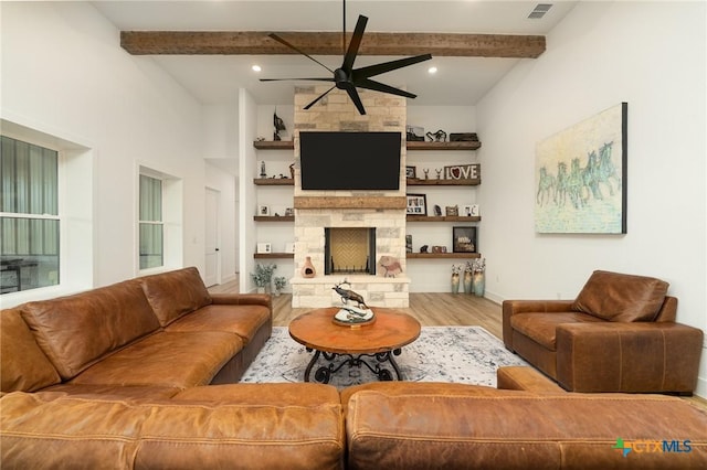 7817 W Fm 487, Florence, TX 76527 - living area with a ceiling fan, beamed ceiling, a stone fireplace, and wood finished floors