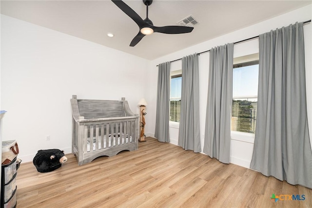 7817 W Fm 487, Florence, TX 76527 - bedroom with a ceiling fan, baseboards, visible vents, wood finished floors, and a crib