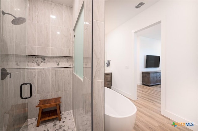 7817 W Fm 487, Florence, TX 76527 - full bath featuring a stall shower, a freestanding bath, visible vents, and wood finished floors
