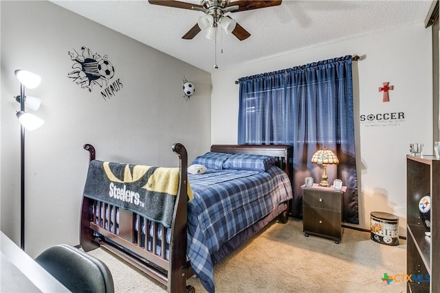 carpeted bedroom with ceiling fan and a textured ceiling