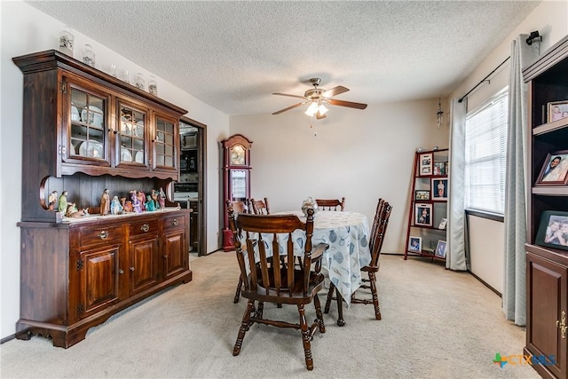 carpeted dining room with a textured ceiling and ceiling fan