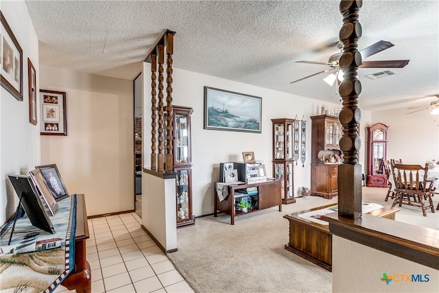 carpeted living room featuring ceiling fan and a textured ceiling