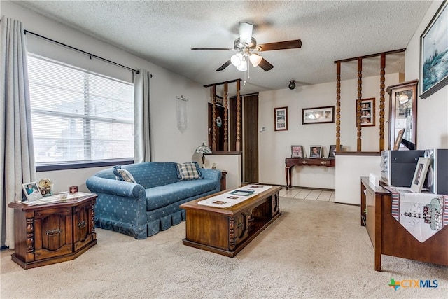 living room with ceiling fan, light carpet, and a textured ceiling