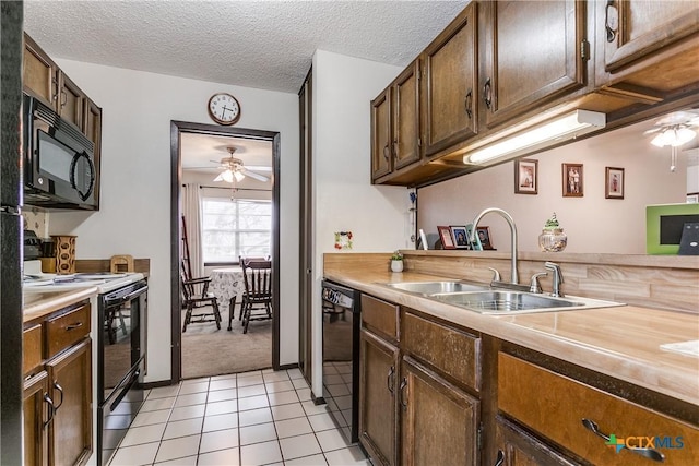 kitchen featuring sink, a textured ceiling, light tile patterned floors, ceiling fan, and black appliances