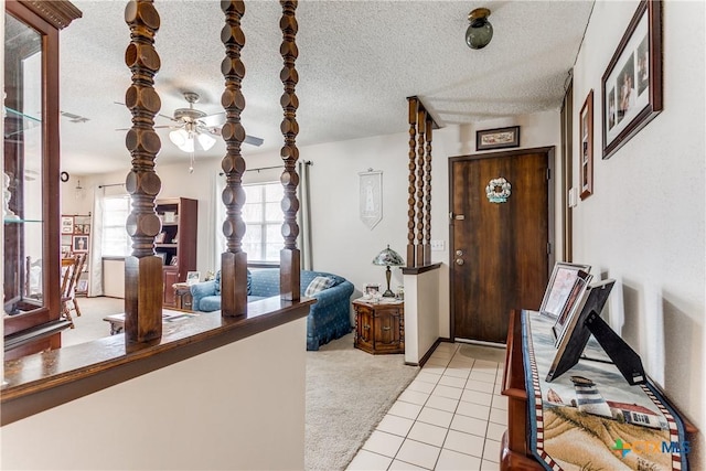 carpeted foyer with a textured ceiling and a wealth of natural light