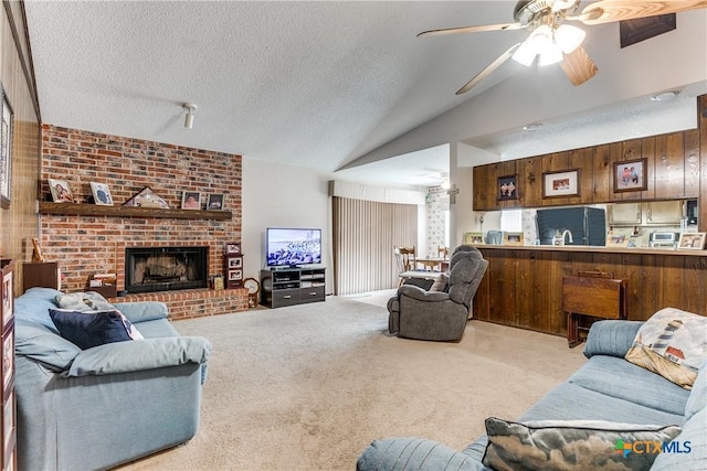 living room featuring lofted ceiling, light carpet, a textured ceiling, and a brick fireplace