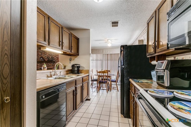 kitchen with sink, a textured ceiling, light tile patterned floors, ceiling fan, and black appliances