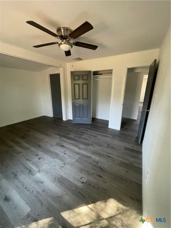 unfurnished bedroom featuring ceiling fan and dark hardwood / wood-style flooring