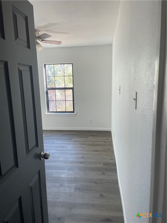 unfurnished room with ceiling fan and dark hardwood / wood-style flooring