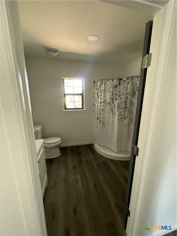 bathroom with curtained shower, vanity, toilet, and wood-type flooring