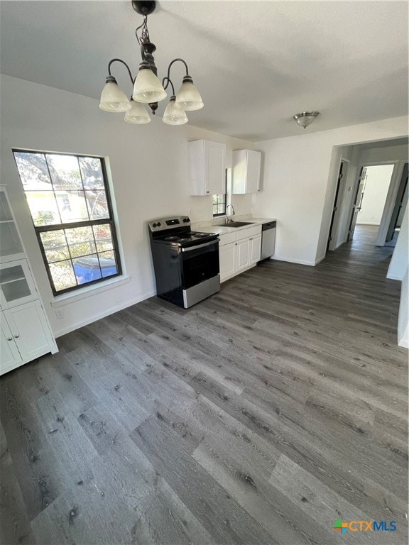 kitchen featuring white cabinets, stainless steel appliances, dark wood-type flooring, and decorative light fixtures