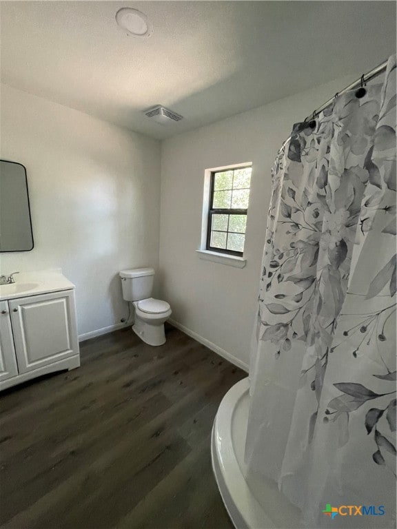 bathroom with toilet, vanity, hardwood / wood-style floors, and walk in shower