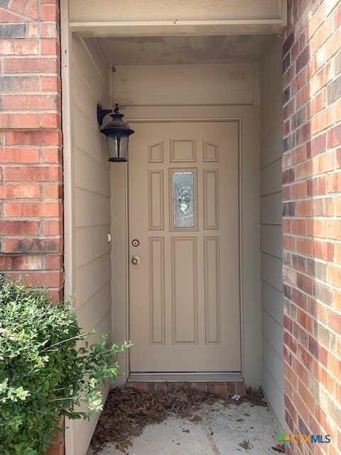 doorway to property with brick siding