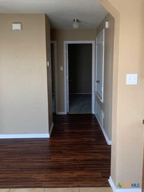 hallway with baseboards and wood finished floors