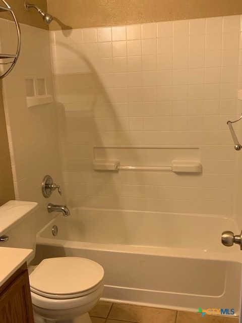 bathroom with tile patterned flooring,  shower combination, toilet, and vanity