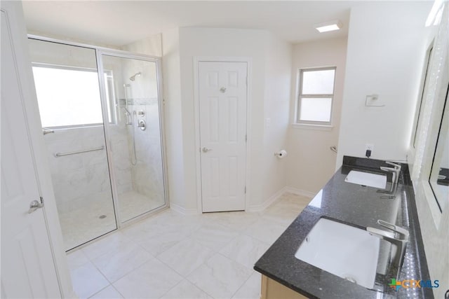 full bath with double vanity, a stall shower, and a sink