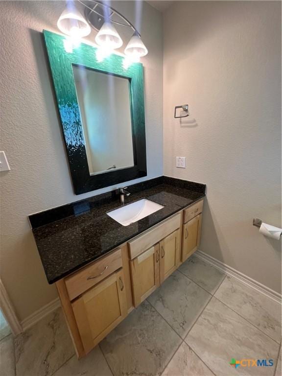 bathroom featuring marble finish floor, vanity, and baseboards