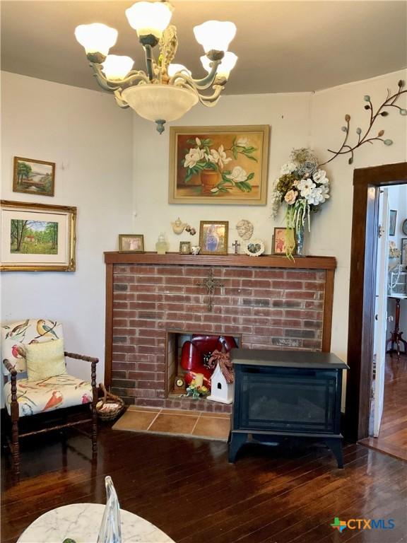 living area featuring a chandelier, a fireplace, and wood-type flooring