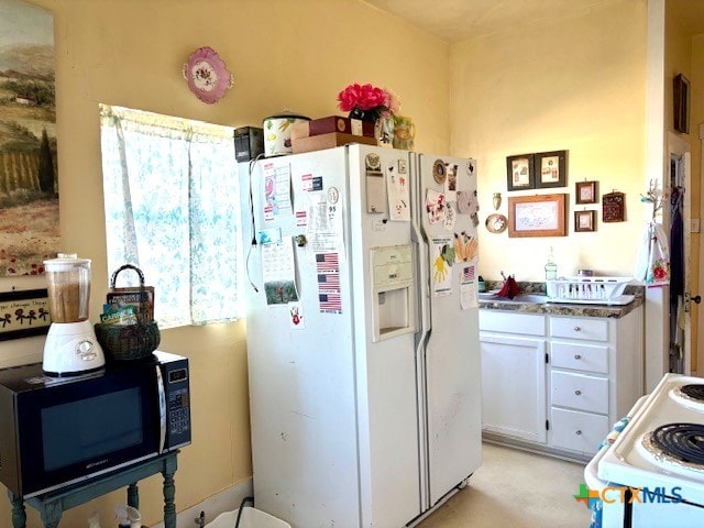 kitchen with white appliances and white cabinets