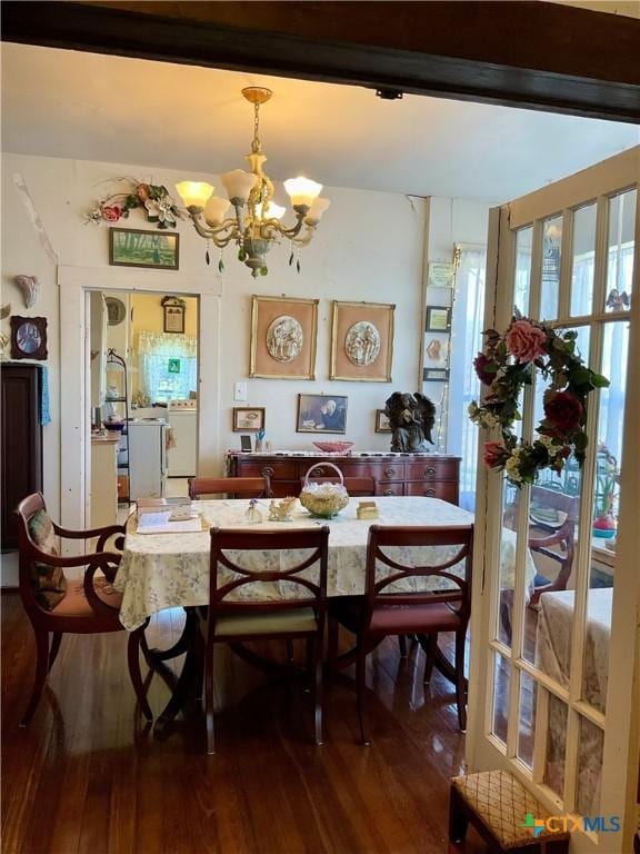 dining space featuring wood finished floors and a chandelier