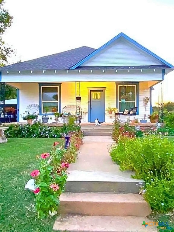 view of front of home featuring covered porch and a front yard