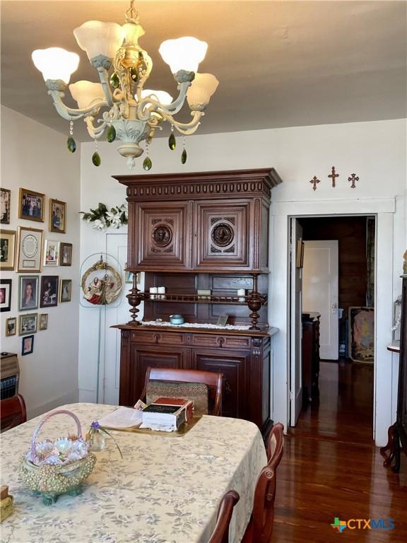 dining room with an inviting chandelier and dark wood-style floors