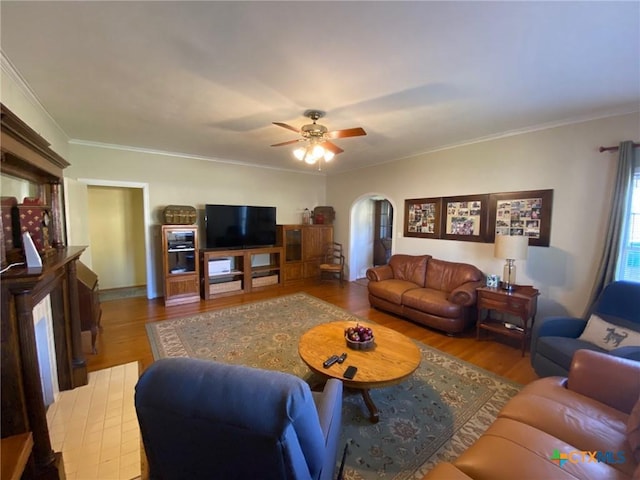 living room featuring light hardwood / wood-style floors, ceiling fan, and crown molding