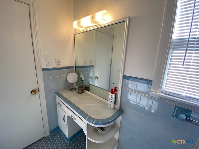 bathroom featuring vanity and tile walls