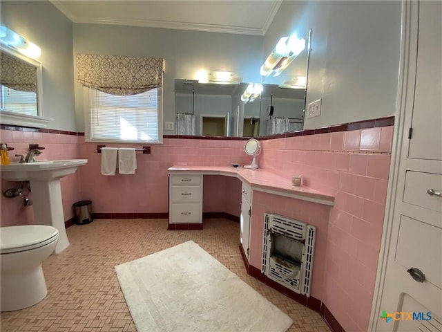 bathroom with toilet, tile walls, crown molding, and heating unit