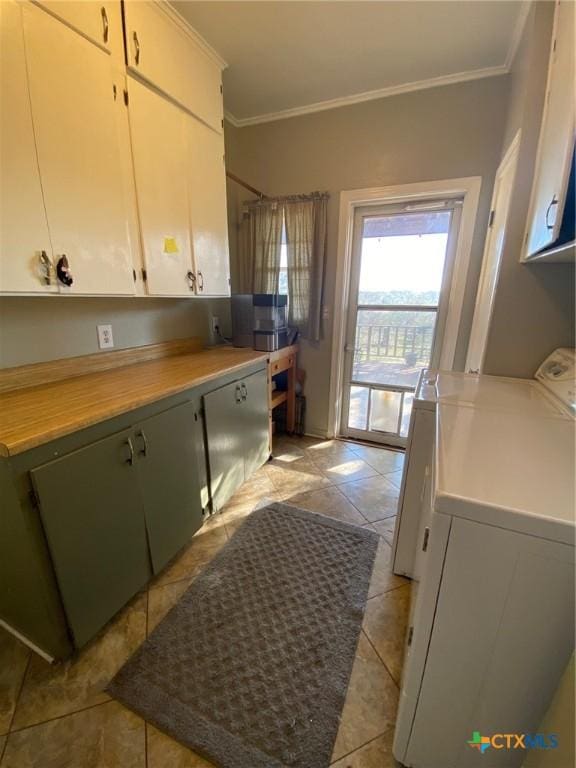 kitchen with washing machine and clothes dryer, white cabinets, light tile patterned flooring, and ornamental molding