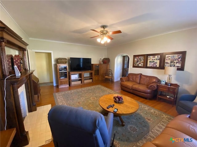 living room with crown molding, ceiling fan, and light hardwood / wood-style floors