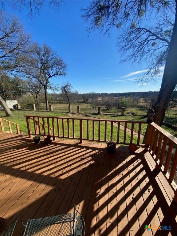 wooden deck featuring a lawn and a rural view