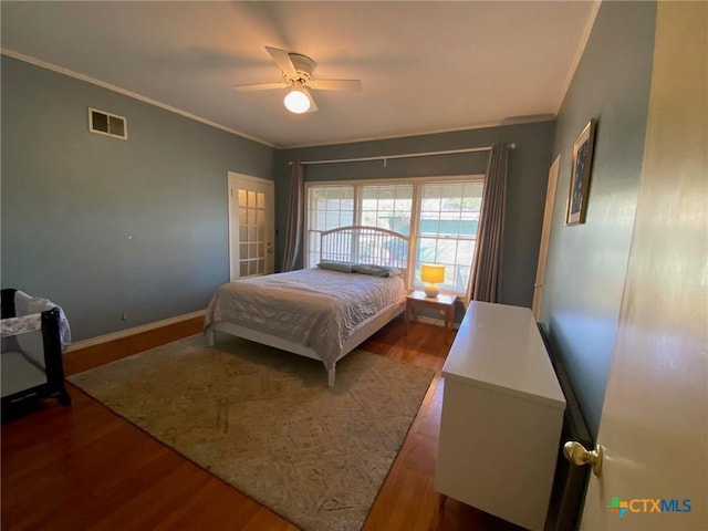 bedroom featuring hardwood / wood-style flooring, ceiling fan, and crown molding