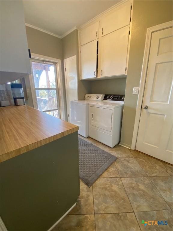 laundry room with cabinets, separate washer and dryer, crown molding, and light tile patterned flooring