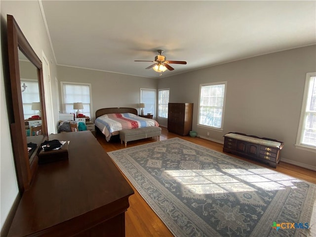 bedroom with ceiling fan, wood-type flooring, and ornamental molding