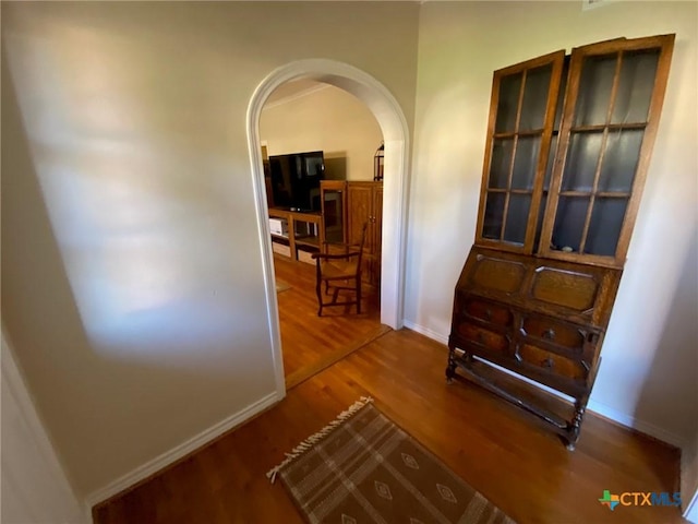 corridor with hardwood / wood-style flooring