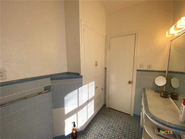 bathroom featuring vanity and tile walls