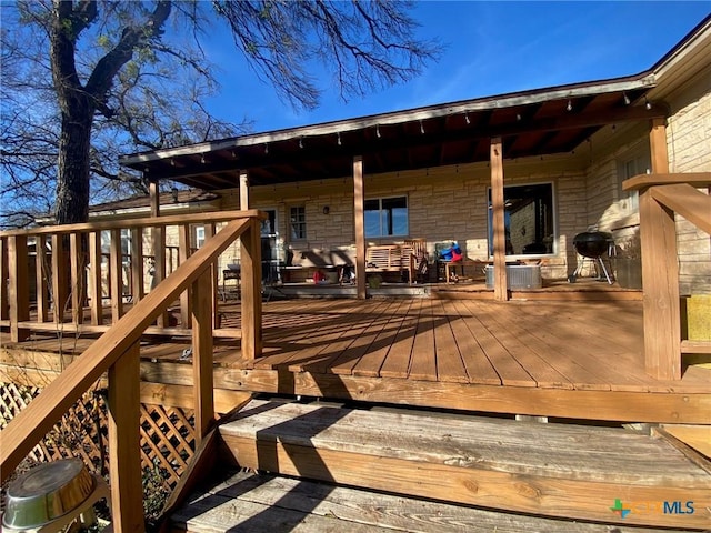 wooden terrace with central AC unit and a grill