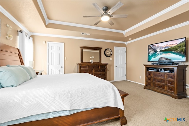 carpeted bedroom featuring a tray ceiling, ceiling fan, and ornamental molding