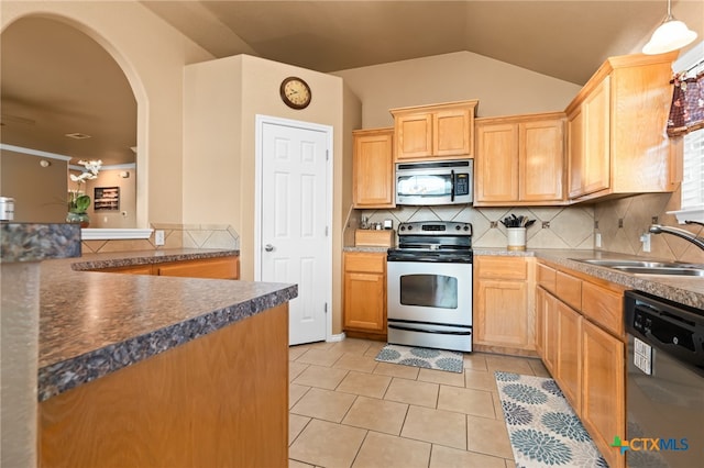 kitchen featuring lofted ceiling, sink, light tile patterned floors, appliances with stainless steel finishes, and tasteful backsplash