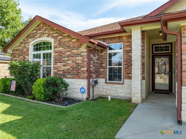 entrance to property featuring a lawn