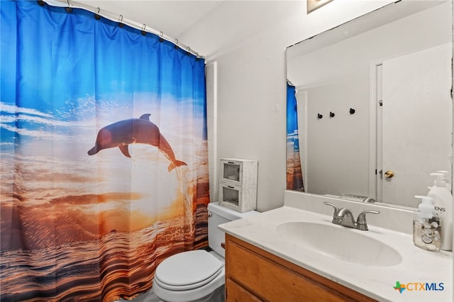 full bath featuring a shower with shower curtain, toilet, and vanity