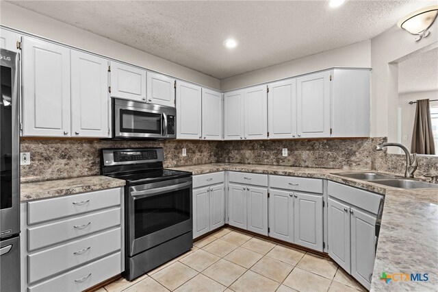4209 Stallion Dr, Killeen, TX 76549 - kitchen featuring stainless steel appliances, a sink, a textured ceiling, backsplash, and light tile patterned flooring